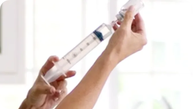 Close up of patient's hand filling syringe