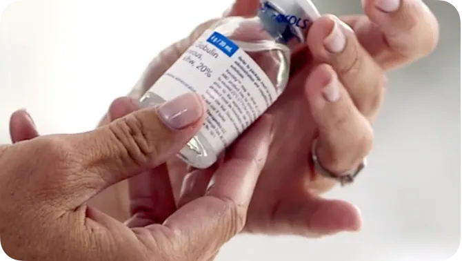 Close up of patient's hand holding vial